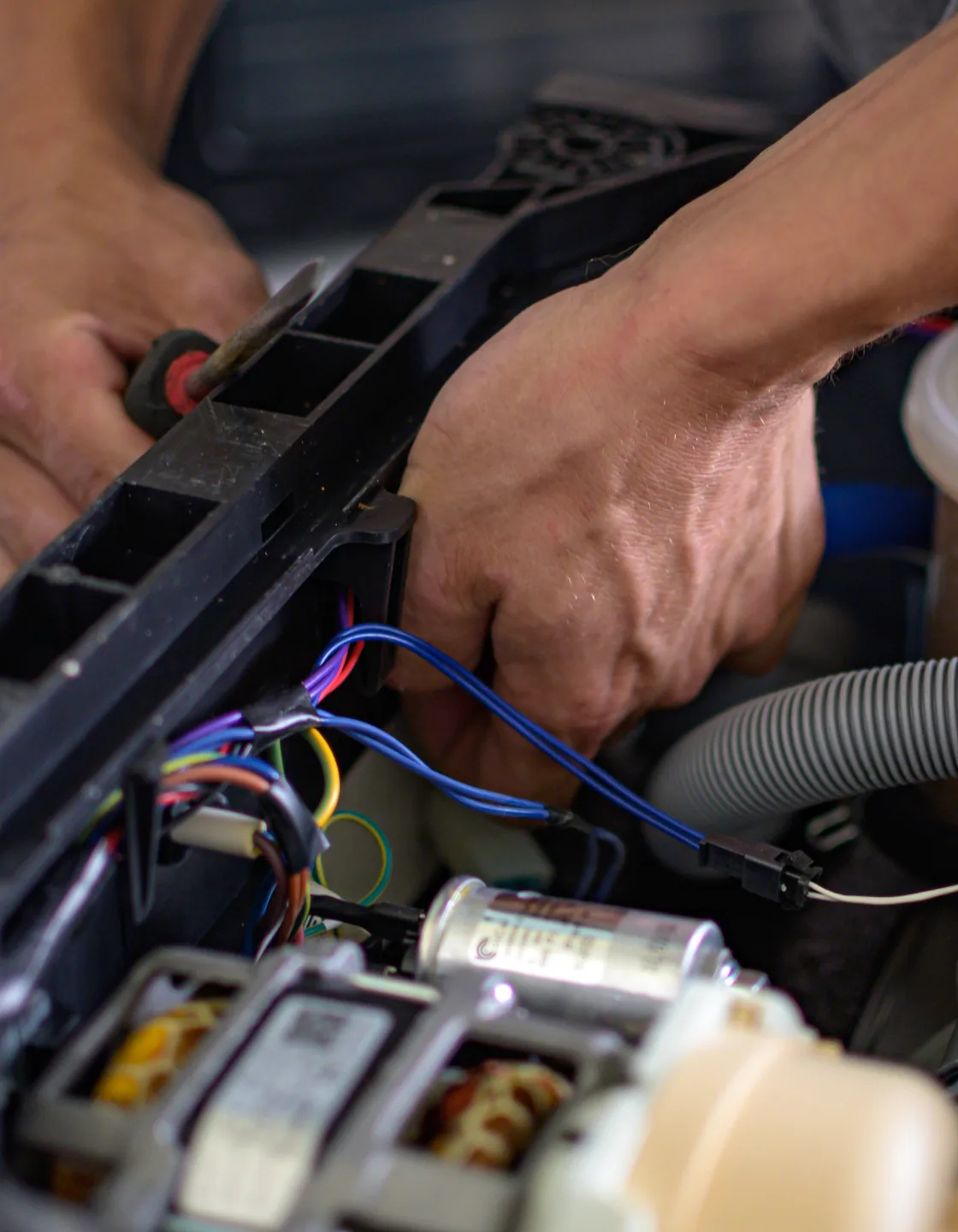 Geöffneter Geschirrspüler mit Verkabelung, Kondensator und Umwälzpumpe bei der Reparatur